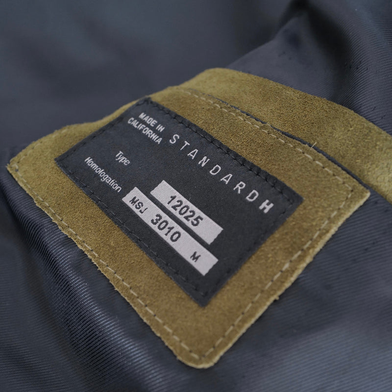 Close-up of a label on a dark fabric surface STANDARD H Mugello Suede Jacket Formula 1 Moto Gp Olive Green Italy Menswear Apparel Outerwear